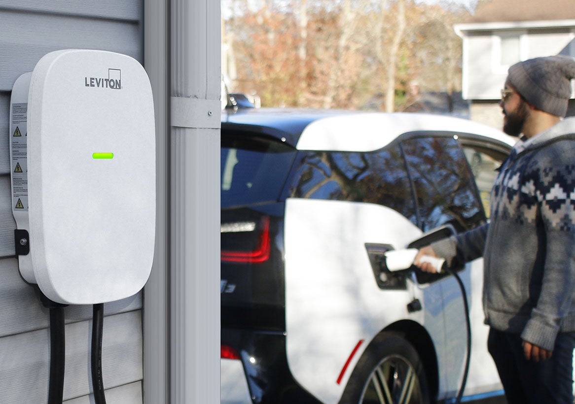 Chargeur de VE branché dans la voiture dans l’allée