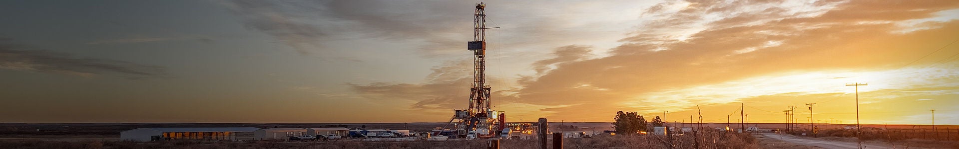 Plate-forme pétrolière terrestre au coucher du soleil