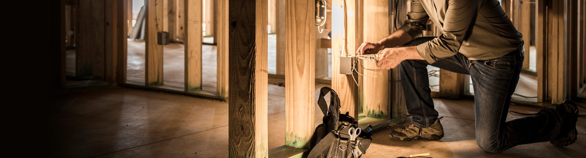 Câblage de l'entrepreneur électricien dans une maison sombre